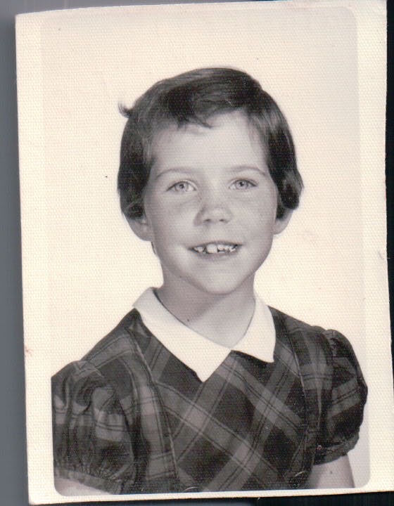 Second-grade school portrait of Kate Horst wearing a plaid dress with white collar.