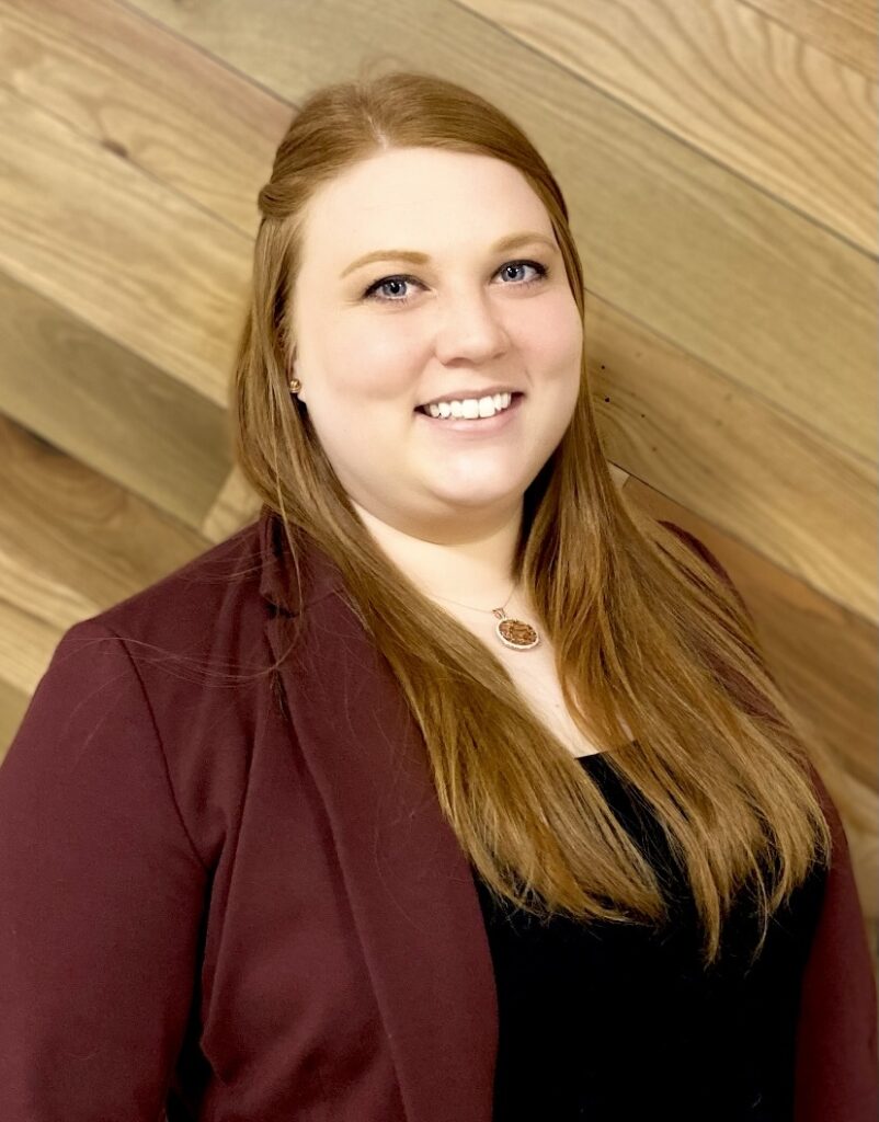 A picture of a white woman with red hair wearing a maroon blazer. This is Terilyn Robles