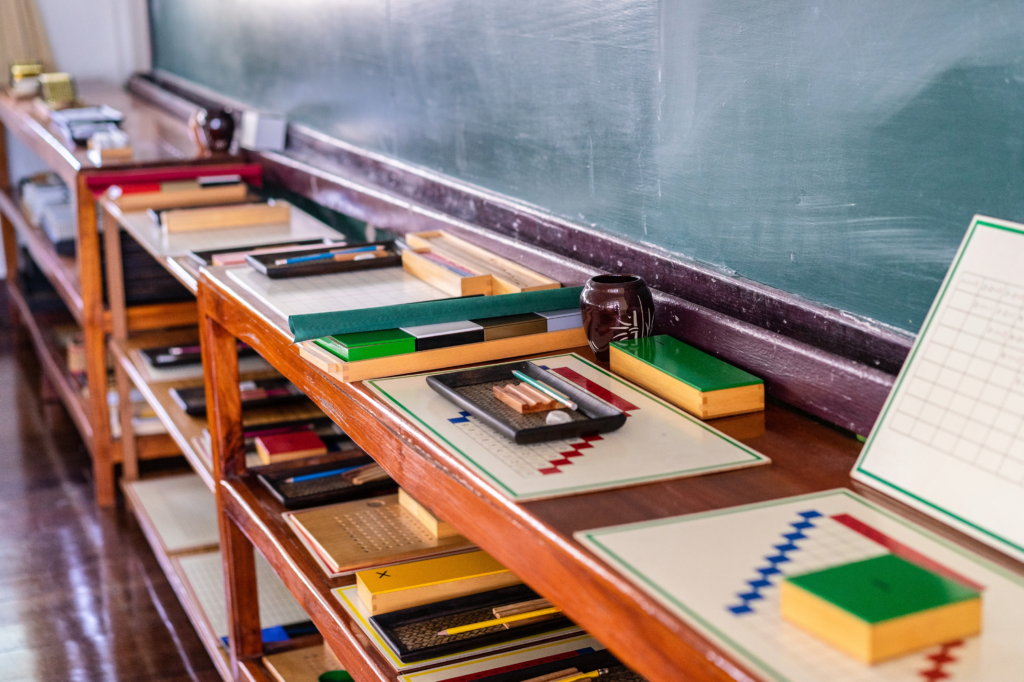 A Montessori classroom similar to Dixon Montessori with graphs and writing equipment lined up against a chalkboard.