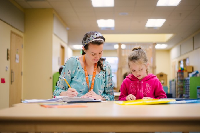 teacher listening while a student reads aloud 