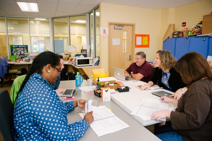 members of a professional learning community conferring at a table