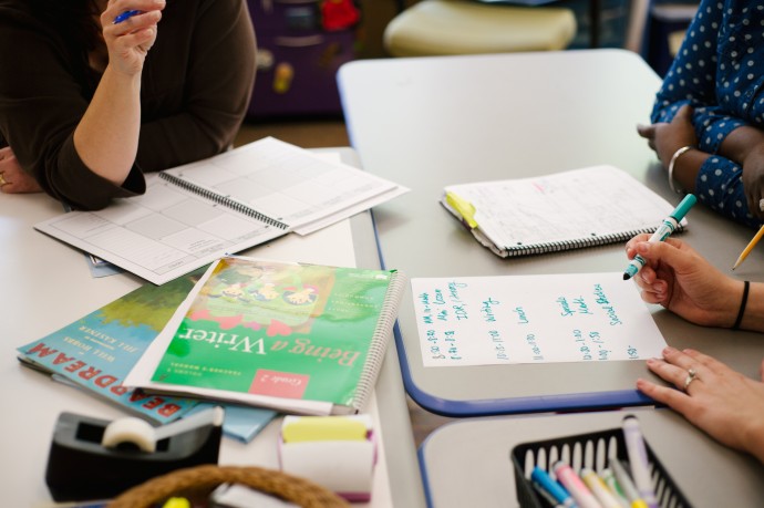 teachers conferring at a table about the school day schedule