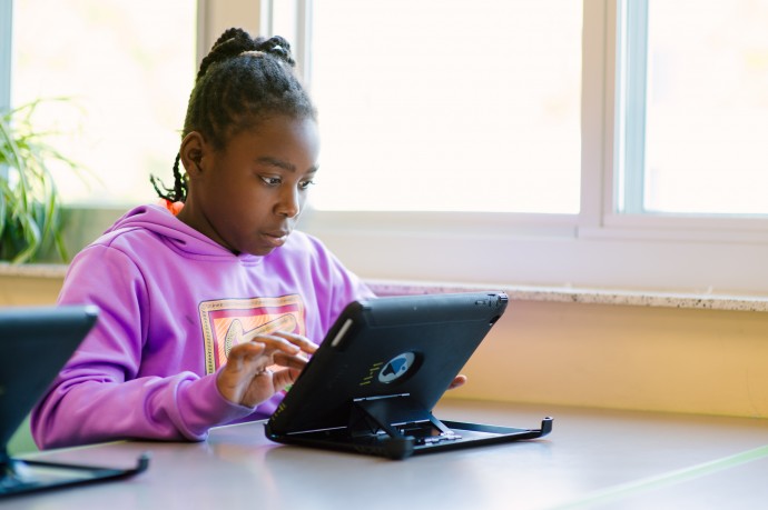 student at a desk using a tablet computer