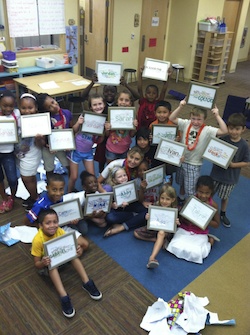 students holding up signs with their names on them