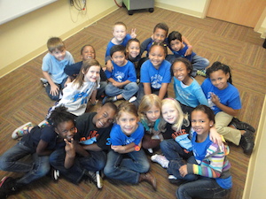 students posing for a group photo on a classroom floor